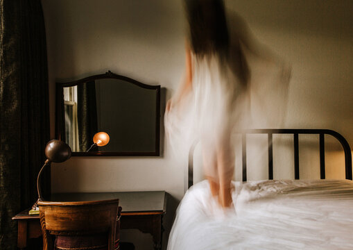 Woman jumping on bed 