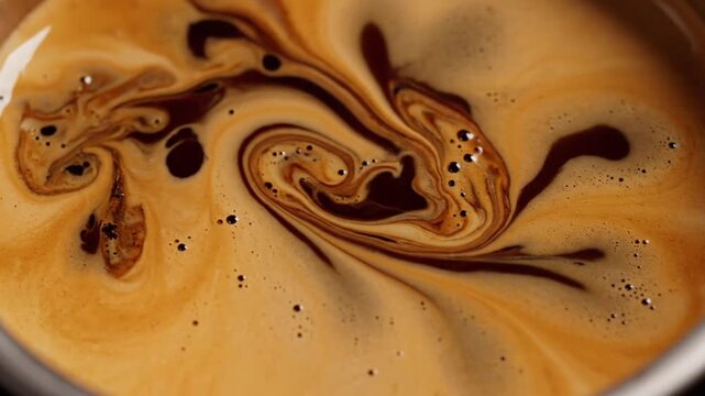 Macro view of espresso pouring into a cup, forming rich golden crema swirls and microfoam textures. Dynamic liquid motion shows dark brown coffee and light tan foam blending together.
