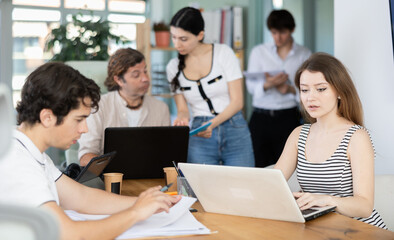 Fototapeta premium Several managers work together in a modern office. A well-coordinated management team