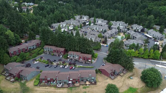 Townhome architectural units align near Kent Des Moines Road transport spine within forest zones. High angle framing details spatial distribution of private residences amidst protected tree belts
