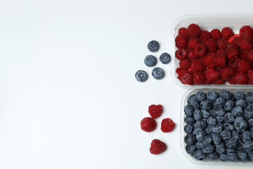 A fresh assortment of blueberries and raspberries set against a white background to showcase organic produce. © Pixora ST 