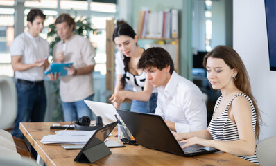 Fototapeta premium Team of managers work together in a modern office with documents and on the Internet