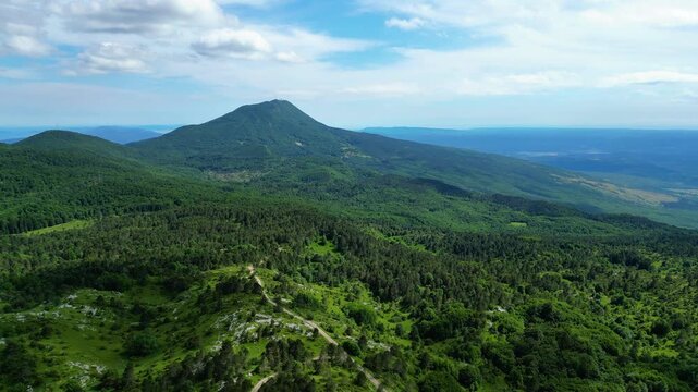 Panoramic aerial view of U?ka Mountain's lush forests meeting the serene Adriatic Sea and Kvarner Gulf islands. A vibrant Croatian landscape on a clear afternoon.