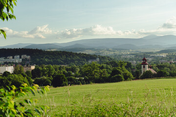 Mountain landscape with a view of Śnieżka peak seen in the distance from Kamienna Góra town, overlooking the valley. © stockcrafter