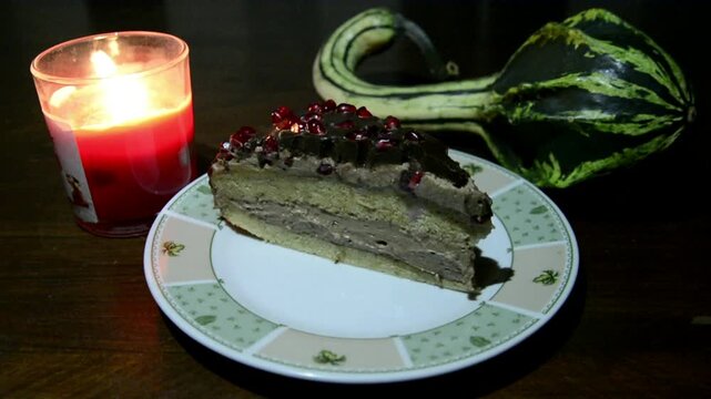 Chocolate with pomegranate cream cake with candle on the board