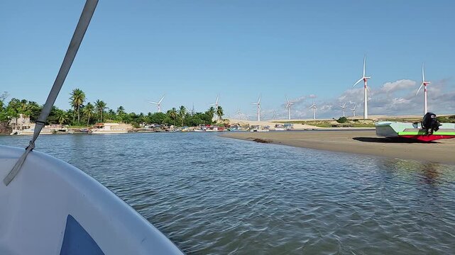 Sailing in Munda&uacute;, Brazil: Point of view shot from a boat showing clear water and massive wind turbines.