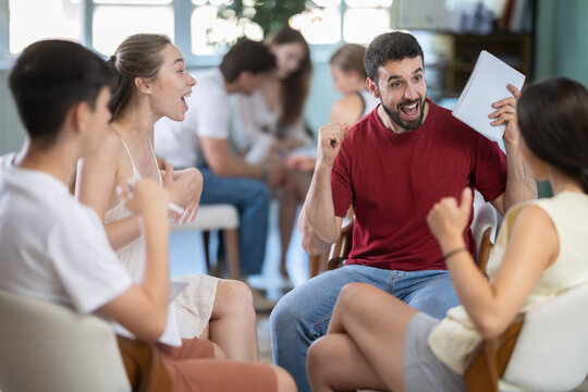 Group of students gathered in circle and rejoiced at victory, exclamations of joy and delight after successful round of intellectual game
