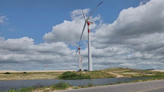 Giant Wind Turbines on Coastal Dunes next to a Lagoon
