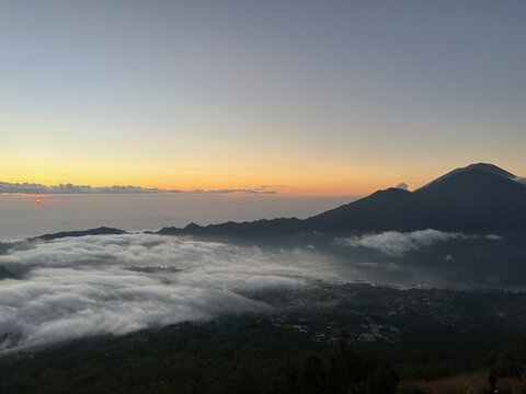 Sunrise over sea of clouds from Mount Batur with volcanic mountain of Mount Agung in Bali, Indonesia