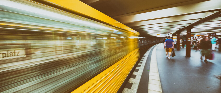 BERLIN, GERMANY - JULY 23, 2016: Yellow subway train speeding up on a city station. Berlin attracts 20 million people annually