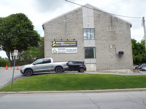 Gatineau,Quebec, Canada &ndash; May 24, 2026: A stone building houses a "Physio Outaouais clinic and a Dentistrie" Dentistry office, with parked vehicles outside today at 366 Chem. d'Aylmer.
