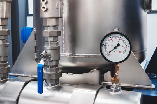 Close-up of stainless steel industrial tank with pressure gauge, tech industrial technology background