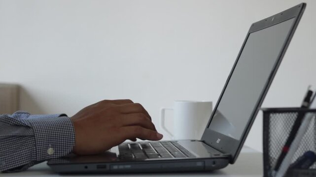 Close up of person typing on laptop with coffee cup on desk in minimalist workspace, concept of remote work, productivity, focus, modern lifestyle, digital workflow and professional online activity