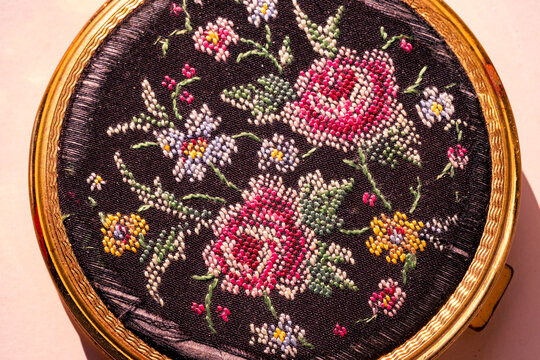 Vintage Austrian powder compact, petit point embroidered floral motif on black silk, ornate gold frame, 19th-century luxury toiletry accessory, cultural heritage Habsburg-era, European aristocracy