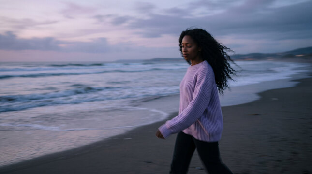 Woman Walking Alone on Beach at Dusk