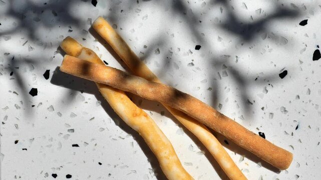 Three natural miswak sticks photographed in warm sunlight with decorative leaf shadows. Eco-friendly oral hygiene accessory made from Salvadora persica. 4k footage