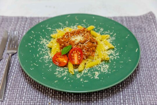 Penne Pasta with Bolognese Sauce on Green Plate