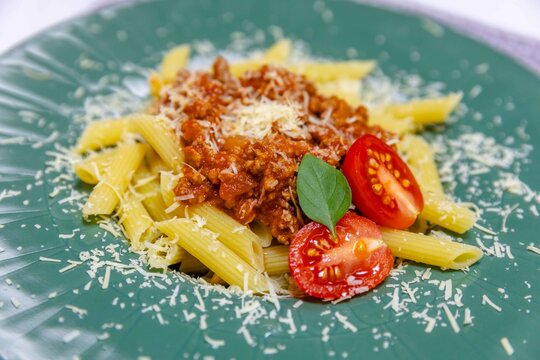 Penne Pasta with Bolognese Sauce on Green Plate