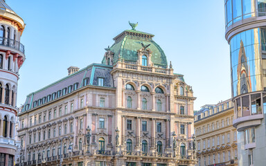 Fototapeta premium The image showcases a stunning historic building in Vienna, Austria, featuring ornate architecture with stunning details, and a gorgeous green dome against a clear blue sky. The refle