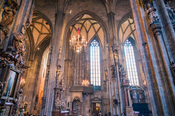 Obraz premium Vienna, Austria - June 4, 2022: The majestic interior of St. Stephen's Cathedral showcases stunning gothic architecture with ornate stone details magnificent windows and warm ambient light