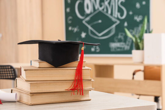Black graduation cap with a red tassel on a stack of old books education and academic achievement in a classroom, this image the culmination of hard work and dedication in the pursuit of knowledge