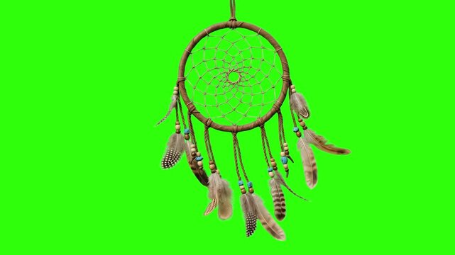 A classic handmade Native American dreamcatcher with a woven web, hanging feathers, and beads sways gently. This protective amulet asset is isolated on a chroma key green screen.