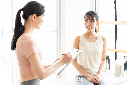 ピラティススタジオで話を聞く女性