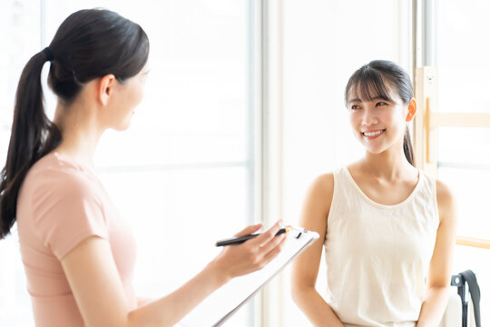 ピラティススタジオで話を聞く女性