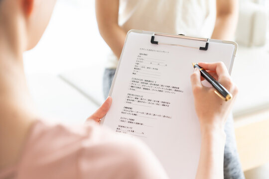 ピラティススタジオで話を聞く女性