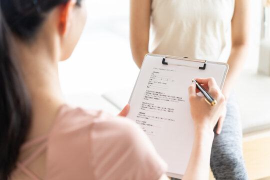 ピラティススタジオで話を聞く女性