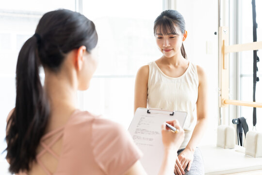 ピラティススタジオで話を聞く女性