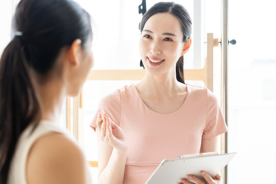 ピラティススタジオで話を聞く女性