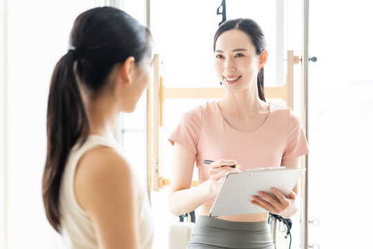 ピラティススタジオで話を聞く女性