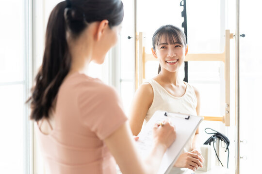 ピラティススタジオで話を聞く女性