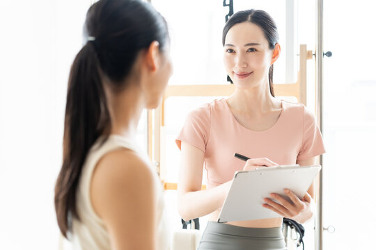 ピラティススタジオで話を聞く女性