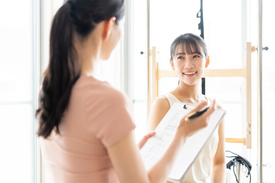 ピラティススタジオで話を聞く女性