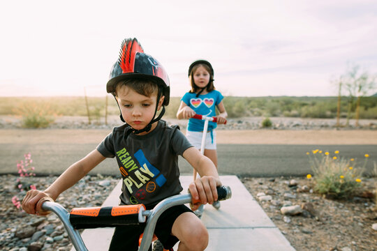 boy and girl riding bike and scooter