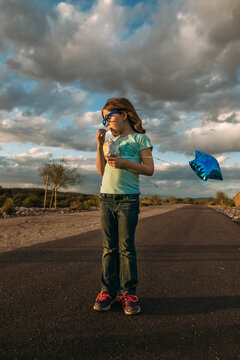 Girl with balloon standing on desert path