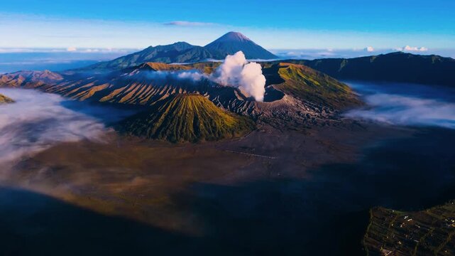 A sweeping aerial perspective capturing the dramatic, ash-covered landscape of the Bromo Tengger Semeru National Park at dawn.