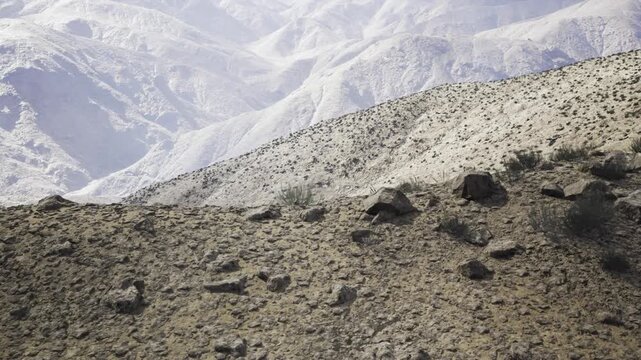 Approach to summit along narrow ridge, leading line of trail and rock formations, sweeping valley below with layered peaks, strong perspective for adventure