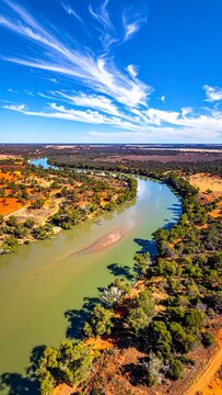 Vibrant river winding through arid landscape under blue sky