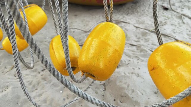 Yellow Plastic Buoys on Twisted Rope. Cinematic motion close up