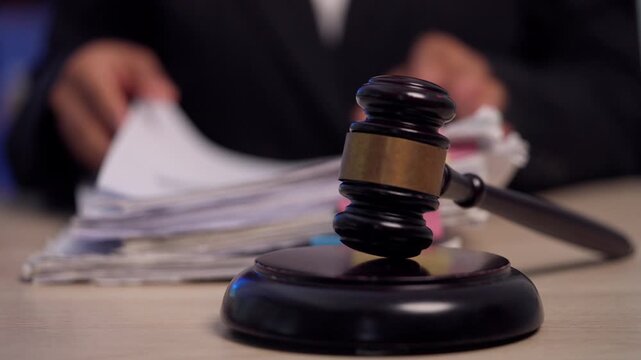 Judge's Gavel on Desk with Lawyer Reviewing Legal Files in Law Office