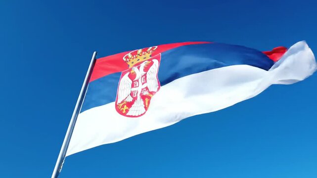 Serbian Flag Waving Proudly Against Clear Blue Sky