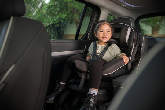 happy preschool child girl sitting in car seat, safety baby chair travelling