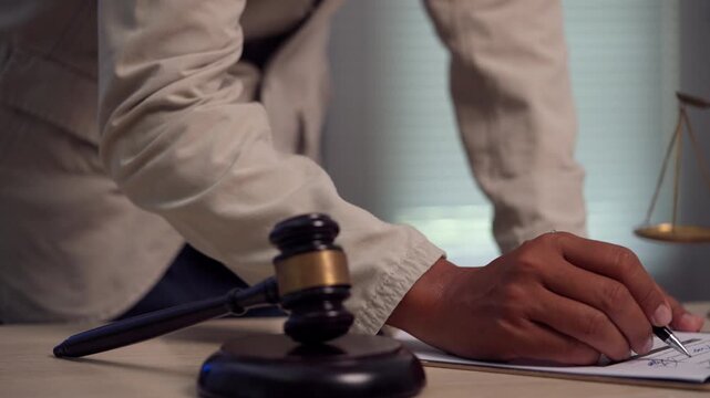 Lawyer Reviewing Contract Before Signing with Judge Gavel and Scales of Justice