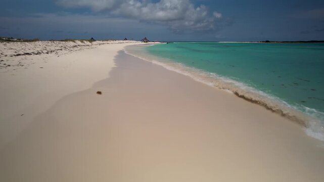 Drone low angle shot Cayo de Agua beach island in Los Roques archipelago in Venezuela, known for its stunning turquoise waters and fine white sand.