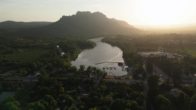 Drone approaching the Rocher de Roquebrune Mountain and River, sunny evening