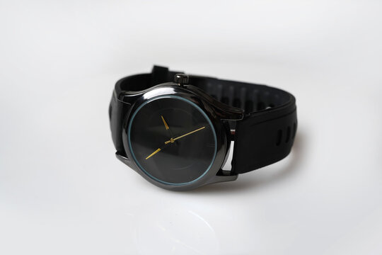 Minimalist Black Analog Watch with Gold Hands and Rubber Strap on White Background