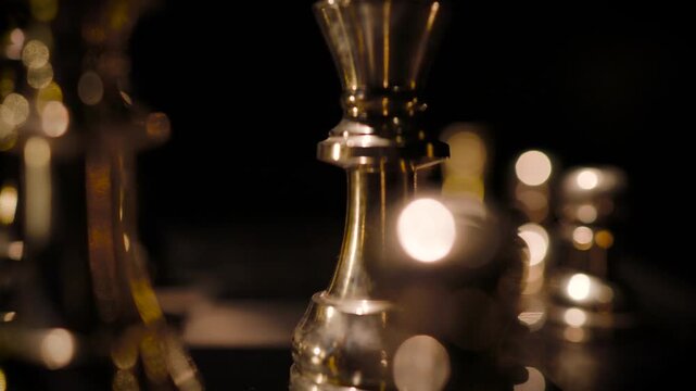 A single chess piece illuminated by a small light source in a completely dark background creating a mysterious dramatic scene.